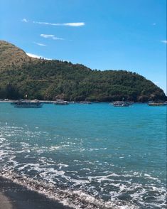 boats are floating in the water on a beach