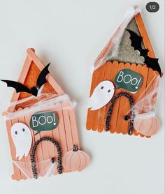 two popsicle houses decorated to look like bats and ghostes with boo written on them