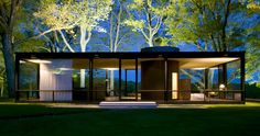 the glass house is surrounded by trees and grass