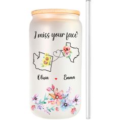 a glass jar with the words i miss your face and two flowers on it next to a straw