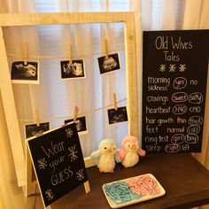 two stuffed animals sitting on a table next to a chalkboard with old wives tales written on it