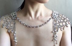 a woman wearing a necklace with pearls on it