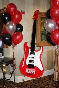 a guitar and some balloons in a room