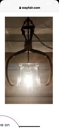 a light hanging from the ceiling with a chain around it and a glass block in the center