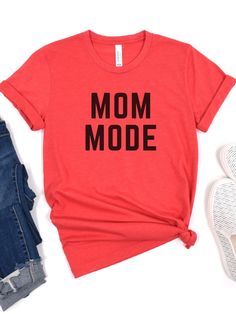 Introducing our Mom Mode Jersey Short Sleeve T-Shirt, the perfect way for any mom to show off her busy and multitasking life. This Bella + Canvas brand t-shirt is available in 16 different colors, so you can choose the one that best suits your style. It's also available in 5 different sizes, so you can find the perfect fit. The phrase "Mom Mode" is prominently displayed on the front of the t-shirt in bold black font, making a bold statement about your mom status. Made from a soft and comfortable Casual Red T-shirt For Mother's Day, Casual T-shirt For Mother's Day, Red Casual Tops For Mother's Day, Casual Red Tops For Mother's Day, Black T-shirt With Funny Text For Mother's Day, Black Top With Funny Text For Everyday, Casual Black T-shirt For Mother's Day, Mom Status, Bold Black