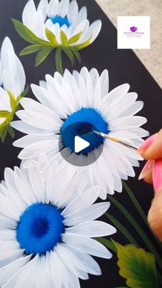 someone is painting flowers with acrylic paint on a black background and has blue tips