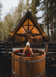 a woman sitting in a wooden hot tub