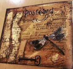 a wooden plaque with a key and some writing on it that says postcard 3