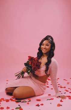 a woman sitting on the ground holding flowers