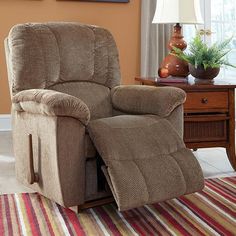 a living room with a brown recliner and striped rug