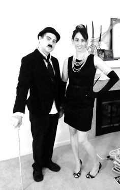 a man and woman dressed in black posing for the camera with fake mustaches on their heads