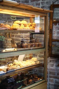 a display case filled with lots of different types of pastries and muffins