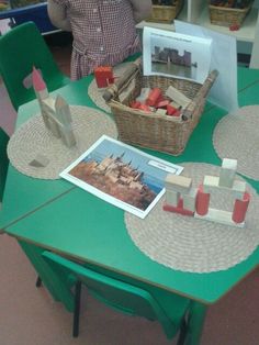 a green table topped with lots of wooden blocks