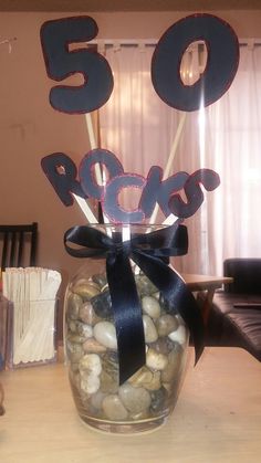 a glass jar filled with rocks sitting on top of a table