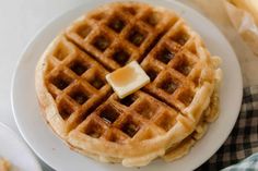 a waffle with butter on top sitting on a plate