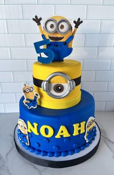 a blue and yellow cake with a minion on top