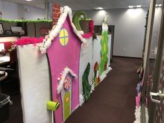 an office cubicle decorated in pink, green and white with decorations on the walls