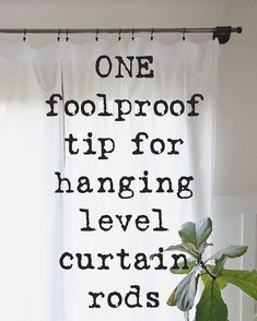 a plant sitting on top of a wooden table next to a white curtain with the words one foolproof tip for hanging level curtains