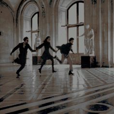 three people are dancing in an old building