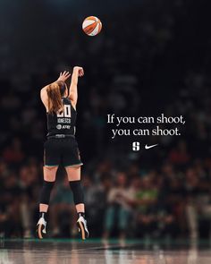 a woman jumping up in the air to hit a basketball