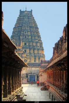 an old building with many pillars and towers in the middle, surrounded by other buildings