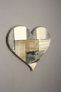 a heart shaped wooden wall hanging on a gray wall