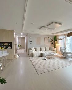 a living room with white furniture and large windows