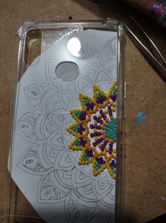 a cell phone case with an image of a flower in the center and beads on it