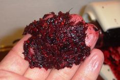 a person holding something in their hand with cranberry sauce on it