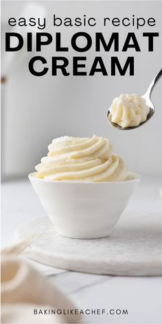 a white bowl filled with whipped cream on top of a table next to a spoon