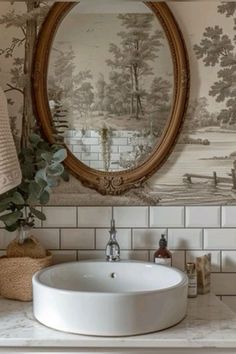 a bathroom sink sitting under a mirror next to a wall mounted faucet in front of a painting