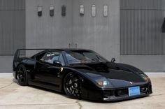 a black sports car parked in front of a building