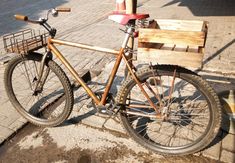 a bicycle parked on the side of a street next to a wooden box and fire hydrant