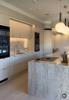 a modern kitchen with marble counter tops and white cabinets