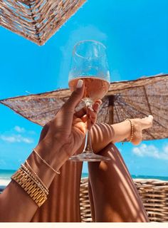 two people toasting wine glasses on the beach