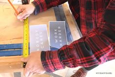 a person measuring the width of a piece of wood