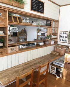 the inside of a coffee shop with wooden tables and chairs, signs on the wall