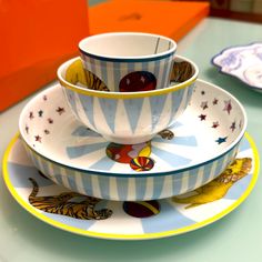 a stack of dishes sitting on top of a table next to a plate and bowl