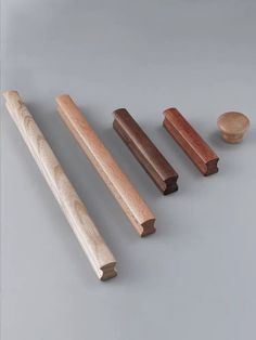 four different types of wood on a gray surface with one wooden object in the foreground