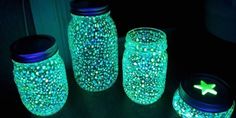 three jars are lit up in the dark with stars on them and one has a green star