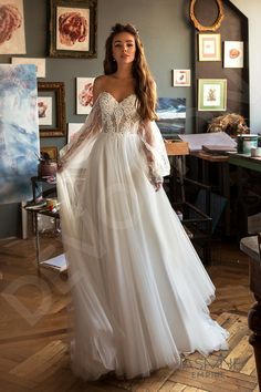 a woman in a wedding dress standing in an art studio