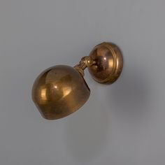 an antique brass wall light on a white wall