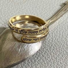 This personalized custom-engraved gold-filled ring is a delicate treasure designed to commemorate special moments and serve as an ideal Bat Mitzvah gift.  Crafted with meticulous attention to detail, this slim and elegant gold-filled ring becomes a canvas for your expression with the option to engrave up to 100 characters. The Hebrew engraving reads:  'Noam, Our little girl, The Lord will guard you, going and coming, Now and Forever.' This verse is a part of 'Shir Lama'alot' - The Song of Ascent Spiritual 14k Gold Engraved Wedding Ring, Personalized Dainty Gold Engraved Ring, 14k Gold Engraved Spiritual Wedding Ring, 14k Gold Spiritual Engraved Wedding Ring, Spiritual Engraved Yellow Gold Promise Ring, Spiritual Yellow Gold Engraved Promise Ring, Dainty Brass Stackable Rings For Anniversary, Gold Sterling Silver Stackable Engraved Ring, Yellow Gold Brass Engraved Ring For Promise