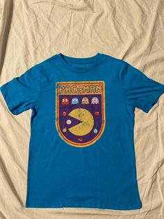 a blue t - shirt with the word pac man on it