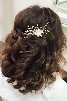 the back of a woman's head wearing a hair comb with flowers on it