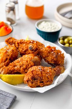 fried chicken on a plate with lemon and olives