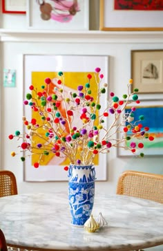 a vase filled with lots of colorful balls on top of a white marble topped table