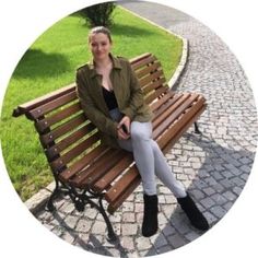 a woman sitting on top of a wooden bench