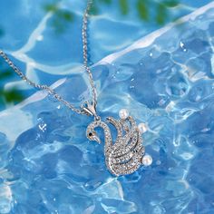 Capturing the grace and elegance of a swan, this pendant sparkles softly enough to complement any outfit. This necklace features a beautiful swan set with numerous sparkling white stones and decorated with pearls on the wings. It is a charming gift for a special someone.Carat Weight: 1.824 ctStone Size: 1,1.2,1.4,3 mmStone Type: Jeulia® StoneNumber of Stones: 101 Stone Shape: RoundStone Color: Diamond White, Fancy BlackWeight: 5.58 gMaterial: Plating Color: Length: 440 mm Elegant Pearl Necklace With Rhinestones For Gift, Beautiful Swan, My Queen, White Stones, Necklace Online, Charm Gift, White Stone, Cultured Pearls, Sterling Silver Necklace