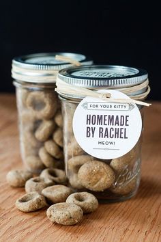 two jars filled with nuts sitting on top of a wooden table